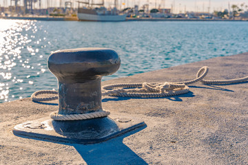 Ship bollard and rope. Harbor.