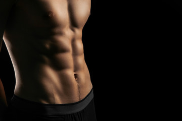 Fototapeta na wymiar pumped handsome male press. Male athletic body closeup on black background