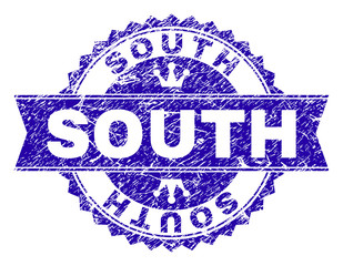 SOUTH rosette stamp seal overlay with grunge style. Designed with round rosette, ribbon and small crowns. Blue vector rubber watermark of SOUTH text with unclean style.
