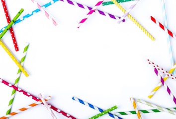 Drinking straws for party on white background. Top view of colorful paper disposable eco-friendly straws for cocktails. Frame from colorful straws for winter cocktails. Place for text, copy space.