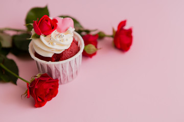 cupcake roses and hearts on a pink background.copy spase.Chocolate cupcakes decorated with cream rose