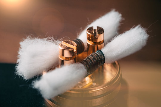 RDA - vape device with Coils and Japanese organic cotton for vaping, close up. E-cigarette or e-cig for alternative smoking
