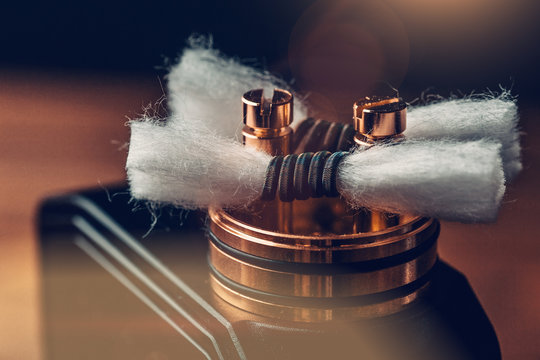 RDA - vape device with Coils and Japanese organic cotton for vaping, close up. E-cigarette or e-cig for alternative smoking