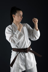 Young woman dressed in traditional kimono practicing her karate moves