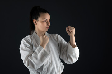 Young woman dressed in traditional kimono practicing her karate moves