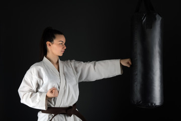 Young woman dressed in traditional kimono practicing her karate moves