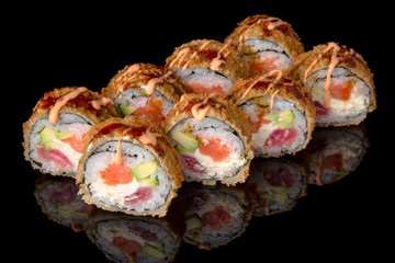 Hot fried Sushi Roll with salmon, tuna, avocado and cheese on black background. Sushi menu. Japanese food. 