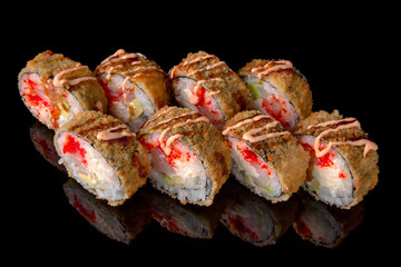 Hot fried Sushi Roll with perch, tobiko caviar, avocado and cheese on black background. Sushi menu. Japanese food. 