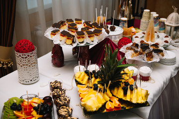 desserts with fruits, mousse, biscuits. Different types of sweet pastries, small colorful sweet cakes, macaron, and other desserts in the sweet buffet. candy bar for birthday