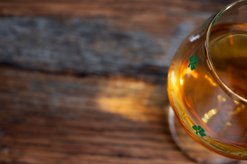 Shamrock Irish Whiskey Glass on Textured Wooden Background Shallow Depth of Field
