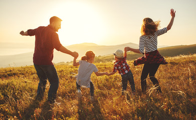 Happy family: mother, father, children son and daughter on sunset.