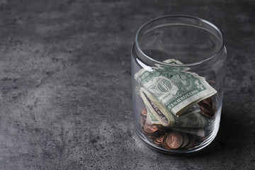 Donation jar with money on grey background. Space for text