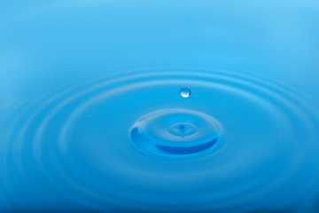 Naklejka na ściany i meble Splash of blue water with drop as background, closeup