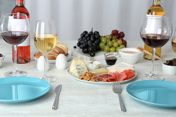 Wine and snacks served for dinner on table at home