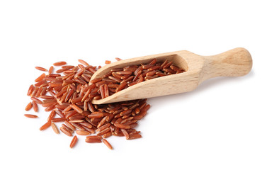 Scoop and uncooked brown rice on white background