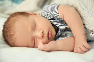 Fototapeta na wymiar Adorable newborn baby peacefully sleeping on bed