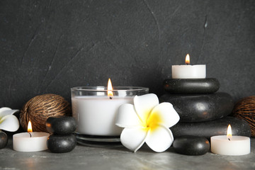 Spa composition with stones and candles on table