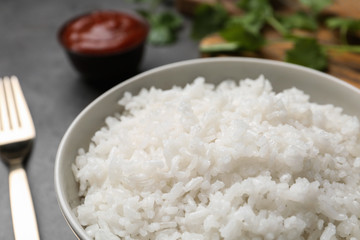 Bowl of boiled rice on table, closeup