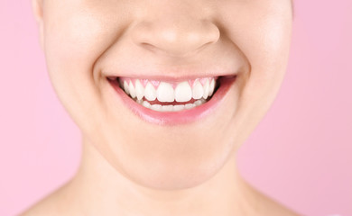 Obraz premium Młoda kobieta z pięknym uśmiechem na kolorowym tle, zbliżenie