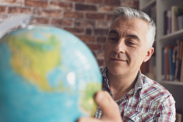 Man holding a globe and finding locations