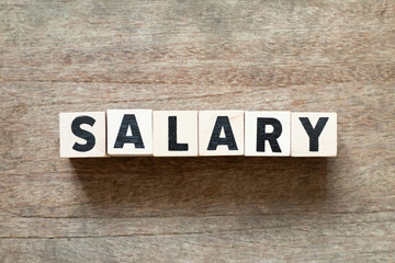Letter block in word salary on wood background
