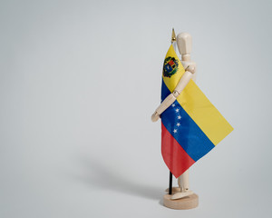 Venezuelan flag held by man made in wood on white background ideal for political and social...