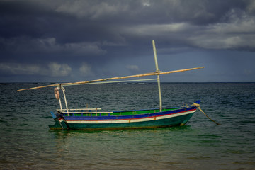 Small wooden boat for fishing on the edge of the sea.