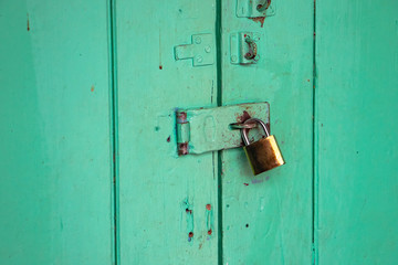 The color vintage wooden door was locked by old metal master key.