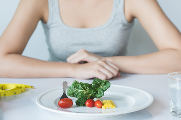 Eat less and eat healthy. person eating vegetable in dinner during control calories on dieting.