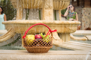 A basket of sprinkled fruit is at the edge of the fountain
