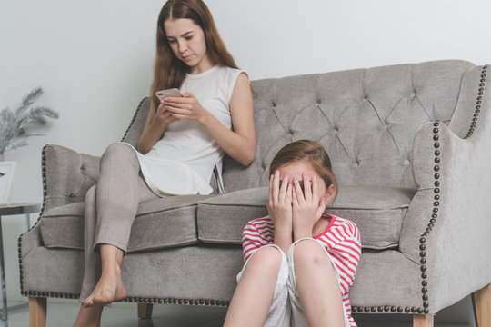 Family Relationship And Social Media. Mum Using Mobile Phone And Ignore Her Child