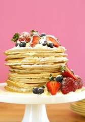 Shrove Pancake Tuesday, last day before Lent, stack of pancakes cake prepared with layers of whipped cream and fresh berries.