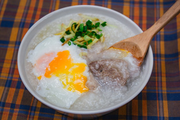 Rice porridge with soft boiled egg, ginger and chopped spring onion.