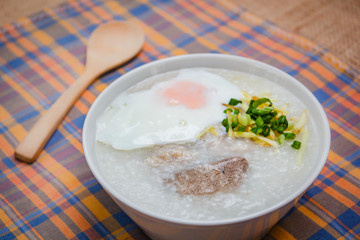 Rice porridge with soft boiled egg, ginger and chopped spring onion.