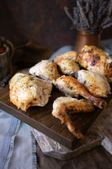 Homemade baked chicken pieces on wooden board