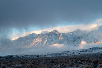 clouds and mist around snowy peaks Sierra Nevada mountains of California, USA