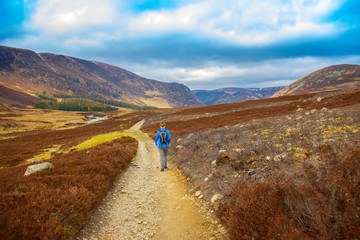 Female hiker walking in Cairngorms National Park. Angus, Scotland, United Kingdom.