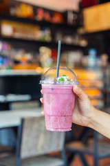 hand holding glass of blueberry smoothies