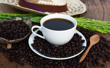 Roasted coffee beans and coffee cup On old wooden floors