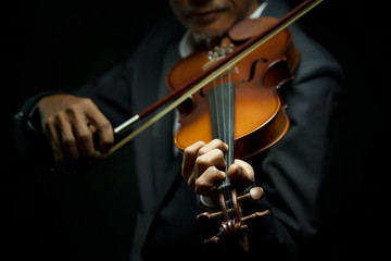 Man playing violin on dark tone