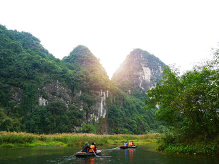 The boat that was paddling along the waterway with high mountains in Halongbok, Vietnam
