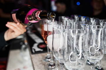 The bartender pours champagne. Waiter pouring champagne at a party