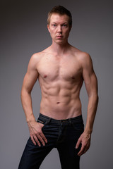 Studio shot of young handsome muscular shirtless man