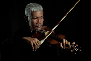  Senior man playing violin and enjoying music on black isolated background portrait