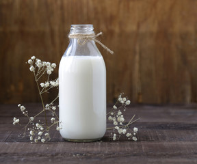 organic milk in a glass bottle on a wooden table