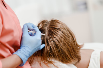 Woman getting mesotherapy injection in head for strengthen hair