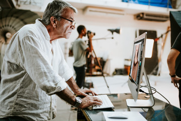 Art director checking photos on a monitor - obrazy, fototapety, plakaty