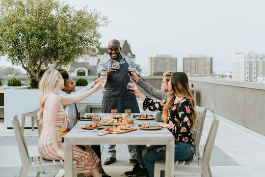 Friends toasting with the chef at a summer party