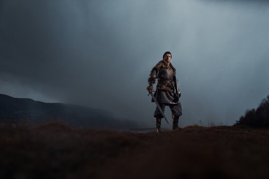 Medieval Knight With Sword And Spear In Ancient Armour Over Winter Landscapes