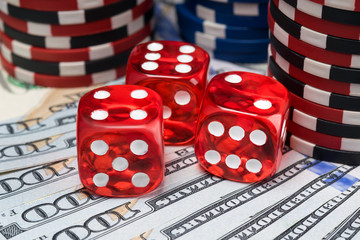 red dice and poker chips are on the background of money